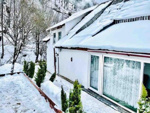 een huis met sneeuw op het dak bij Cozy House in Cavnic, Maramures in Cavnic