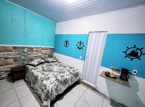 a bedroom with a bed and a nautical wall at Pousada Dule in Guarapari