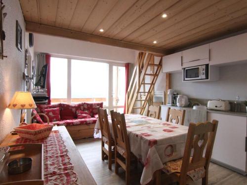 Il comprend une cuisine, un salon et une salle à manger avec une table. dans l'établissement Charmant 4 pièces avec balcon, proche commerces et remontées, Alpe d'Huez, 6 pers, animaux acceptés - FR-1-405-133, à L'Alpe-d'Huez