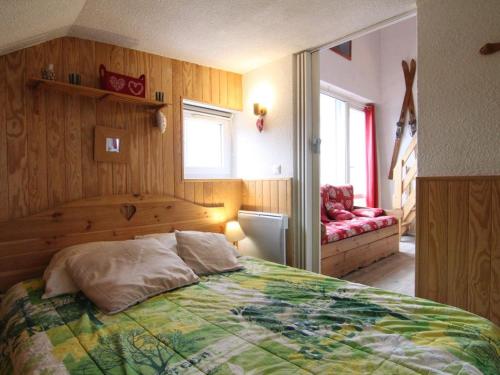 une chambre avec un lit et une chaise rouge dans l'établissement Charmant 4 pièces avec balcon, proche commerces et remontées, Alpe d'Huez, 6 pers, animaux acceptés - FR-1-405-133, à L'Alpe-d'Huez