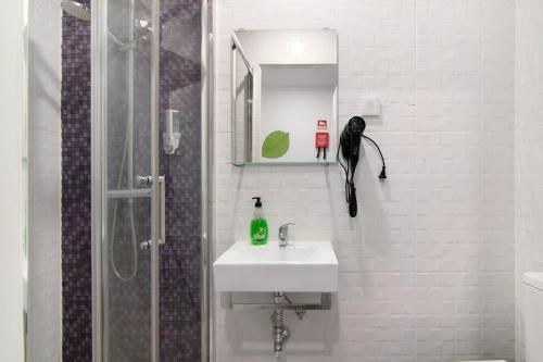 een badkamer met een wastafel en een douche met een zwarte paraplu bij Apartamento Familiar in Moncarapacho