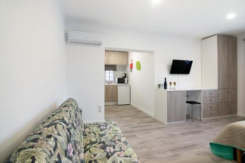 a living room with a couch and a kitchen at Apartamento Familiar in Moncarapacho