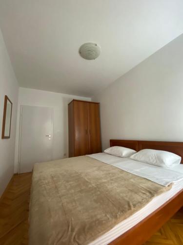 a bedroom with a large bed with white sheets at Apartment VaLi in Herceg-Novi