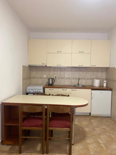 y cocina con mesa, 2 sillas y fogones. en Apartment VaLi, en Herceg-Novi