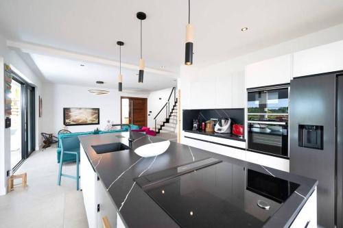 Dapur atau dapur kecil di SUMMER VIEW classée 5 étoiles - Magnifique Villa 10 personnes avec piscine miroir chauffée à 29 degrés, bain à remous intégré et vue mer idéalement située Chemin Summer - ST GILLES LES BAINS
