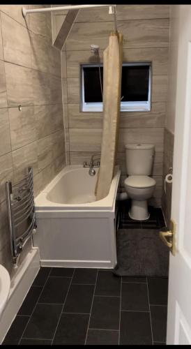 a bathroom with a bath tub and a toilet at Melior Grandiose in Liverpool