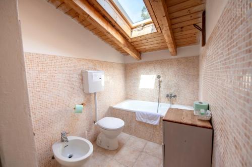W łazience znajduje się toaleta, wanna i umywalka. w obiekcie 207 - Appartamento Mimosa, Terrazza, giardino e Piscina - Residence Cherry House w mieście Carro