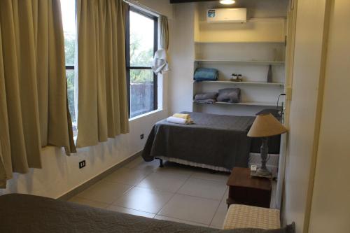a small bedroom with a bed and a window at AP 20- Apart OH in Ciudad del Este