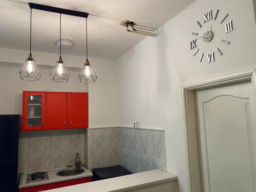 uma cozinha com um relógio na parede e um lavatório em Sunny em Belgrado