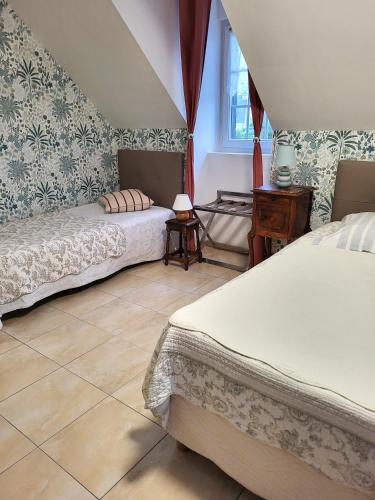 une chambre avec deux lits et une table et une fenêtre dans l'établissement Petit Châtelet bis, à Hirel
