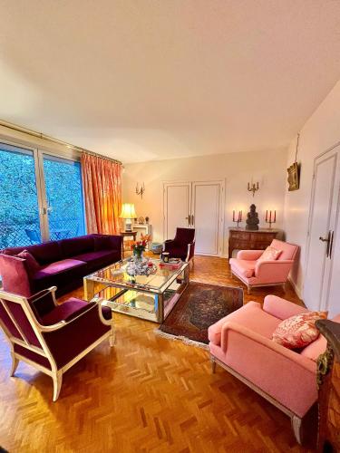un salon avec des meubles roses et une table en verre dans l'établissement Paris luxury apartment, à Paris