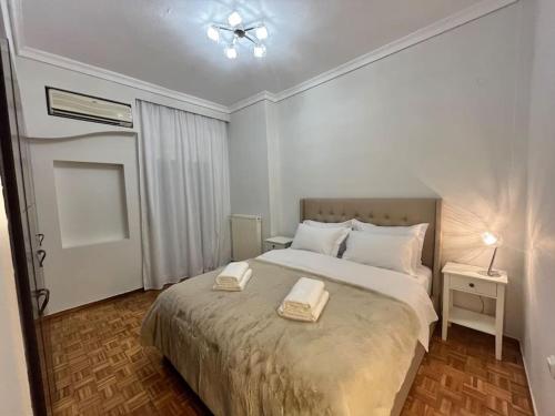 a bedroom with a bed with two towels on it at SKG City Center Apartment in Thessaloniki