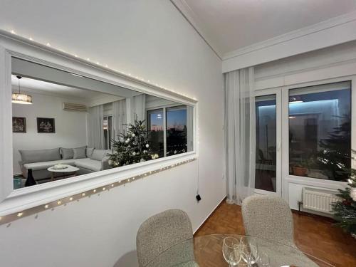 a living room with a couch and a table and windows at SKG City Center Apartment in Thessaloniki