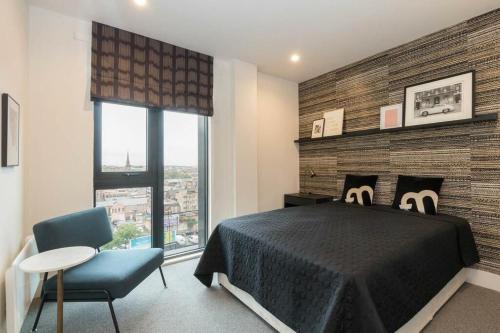 a bedroom with a bed and a chair and a window at Rooms in Birmingham City Centre in Birmingham