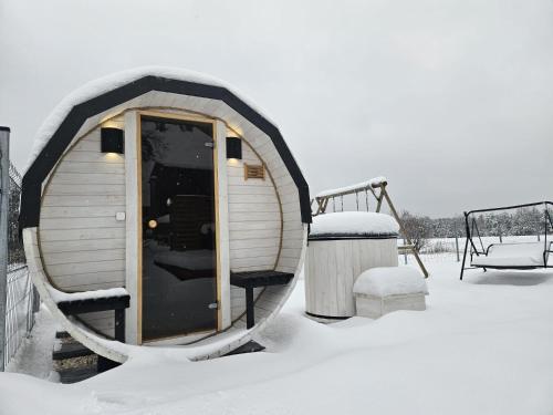 a sauna in the snow next to a swing at DOMKI POD DĘBAMI , Radawa in Radawa