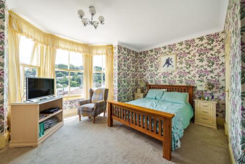 a bedroom with a bed and a desk and a tv at Ingleside in Lynton
