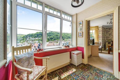 Zimmer mit einem großen Fenster mit einem Stuhl und einem Tisch in der Unterkunft Ingleside in Lynton