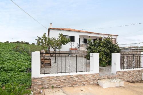 a white house with a gate in front of it at Apartamento Sunset in Moncarapacho