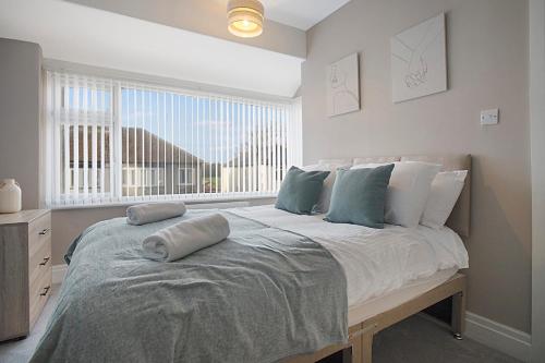 una camera da letto con un grande letto con cuscini sopra di Chic & Peaceful Nook at Clifton Road, Sleeps 5 a Darlington