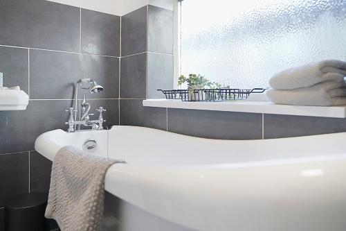 a bathroom with a white tub and a sink at Chic & Peaceful Nook at Clifton Road, Sleeps 5 in Darlington