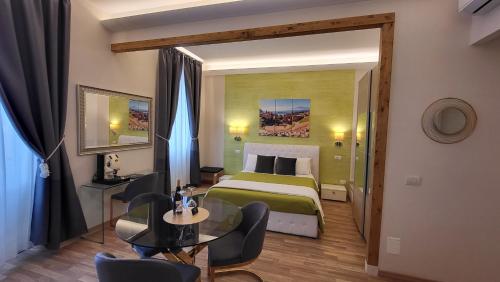 um quarto de hotel com uma cama, uma mesa e cadeiras em I Due Grifoni Studio Flat em Taormina