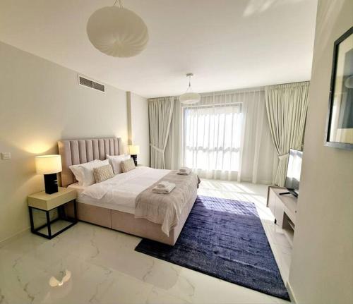 a bedroom with a large bed and a television at Nr to beach-Beautifully upgraded in Dubai