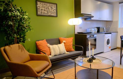 - un salon avec un canapé et une table dans l'établissement GoldersGreen Apartments by Sleepy, à Londres