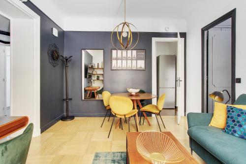 un salon avec une table et des chaises jaunes dans l'établissement Séjours Parisiens / Suite Belle Courcelles / 4*, à Paris