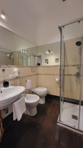 uma casa de banho com um WC, um lavatório e um chuveiro em I Due Grifoni Studio Flat em Taormina