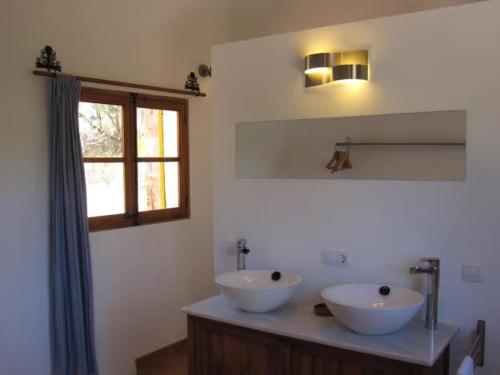 a bathroom with two sinks on a counter with a window at Hostal Catalina Vera in Port d’Andratx