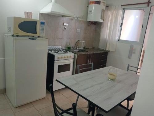 a small kitchen with a table and a microwave at Gotas de Rocio in San Antonio Oeste