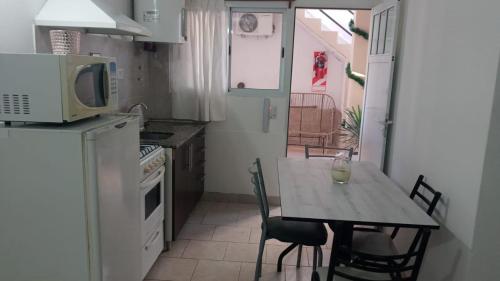 a small kitchen with a table and a microwave at Gotas de Rocio in San Antonio Oeste