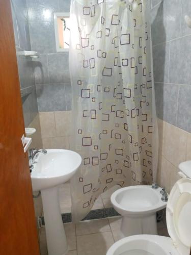 a bathroom with a sink and a toilet and a shower curtain at Gotas de Rocio in San Antonio Oeste