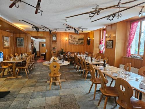 ein Restaurant mit Holzwänden, Tischen und Stühlen in der Unterkunft Hôtel Restaurant du Marchairuz in Le Brassus