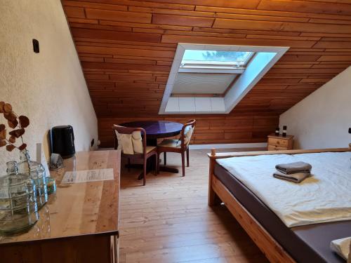 a bedroom with a bed and a desk and a window at Landhaus Bad Rotenfels - Zion in Gaggenau
