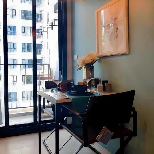 a dining room with a table and a window at THE BASE apartments at central pattaya in Pattaya