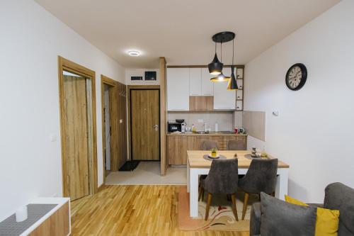 a kitchen and living room with a table and chairs at Apartment Vista In Prestige in Zlatibor