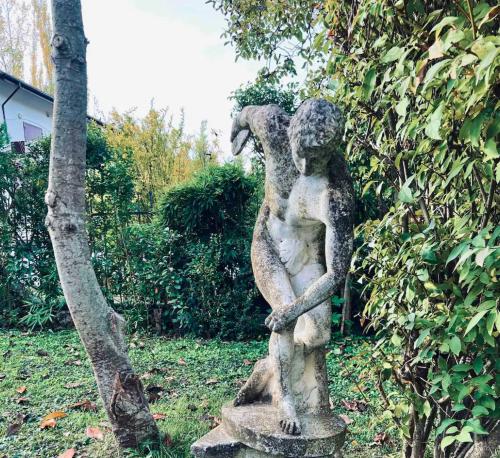 a statue of a woman standing next to a tree at Villa Alberto in Sulmona