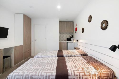 a bedroom with a large bed and a kitchen at Apartamento Mar in Moncarapacho