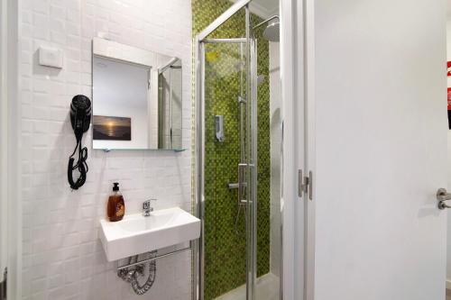 ein Bad mit einem Waschbecken und einer Dusche in der Unterkunft Apartamento Mar in Moncarapacho
