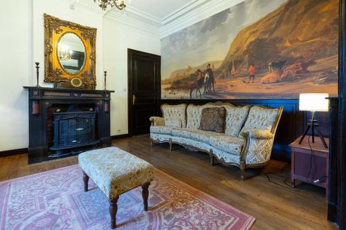 a living room with a couch and a mirror at Château Constance, 19 personnes in La Roche-en-Ardenne