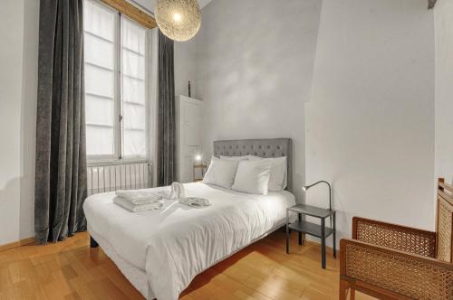 een slaapkamer met een wit bed en een raam bij L'encrier - Appt confortable pour 2 in Toulouse