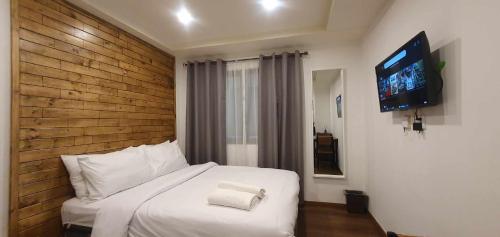 a bedroom with a bed with a television on a wall at JCGA Apartments at Megatower Residences IV - Near SM & Session Rd in Baguio