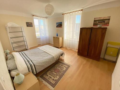 une chambre avec un lit et une commode dans l'établissement LES Herbus angle rue de l'avant-garde et 31 rue Jérémie, à Genêts