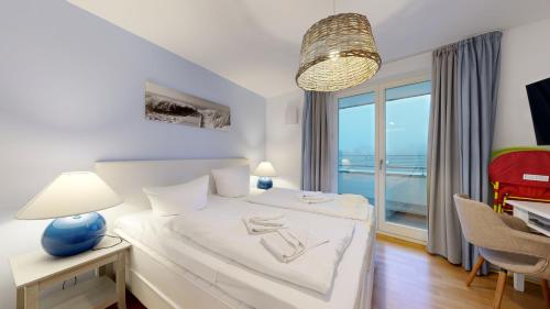 ein Schlafzimmer mit einem Bett mit Blick auf das Meer in der Unterkunft strandnahe FeWos mit Terrasse oder Dachterrasse, Strandhaus Seeblick, Binz in Binz
