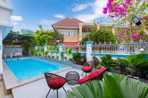 a house with a swimming pool and chairs next to it at A5 Ngọc Tước - Villa Hồ Bơi Gần Biển Bãi Sau - Free Bida + Karaoke in Vung Tau