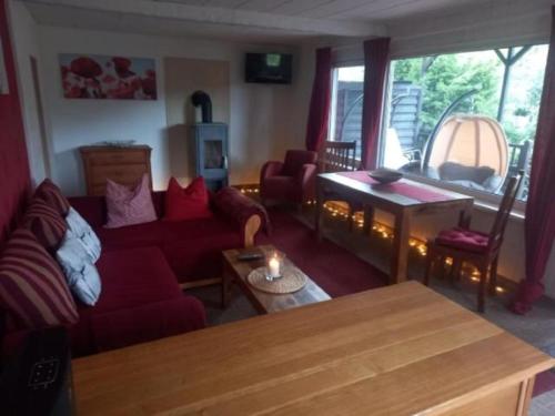 ein Wohnzimmer mit einem roten Sofa und einem Tisch in der Unterkunft Ferienhaus im Odertal in Stolpe