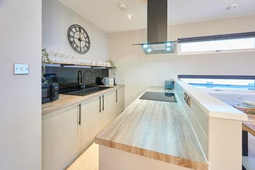 a kitchen with a counter and a clock on the wall at Host & Stay - Ropewalks Quarters in Liverpool