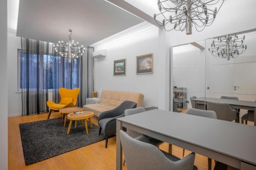 een woonkamer met een bank en een tafel en stoelen bij Central Luxurious 2 BD Flat near NDK in Sofia