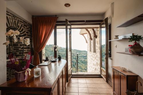 a kitchen with a large glass door with a view at Archontiko Anemos in Makrinítsa